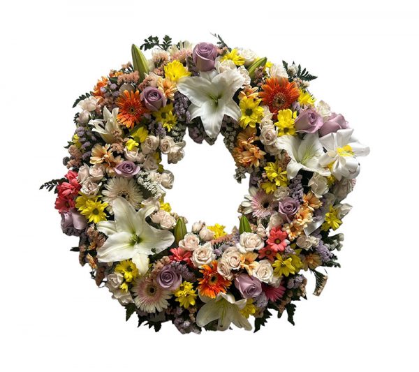 Corona de flores variadas en tonos claros con toques naranjas y malvas
