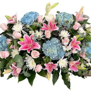 Centro funerario en tonos rosas y azules compuesto por hortensias, liliums y rosas de color rosa