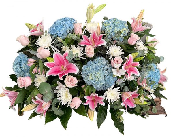 Centro funerario en tonos rosas y azules compuesto por hortensias, liliums y rosas de color rosa