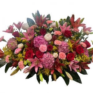 Centro funerario, liliums rojos, hortensias rosas, rosas, tonos rojos y rosas